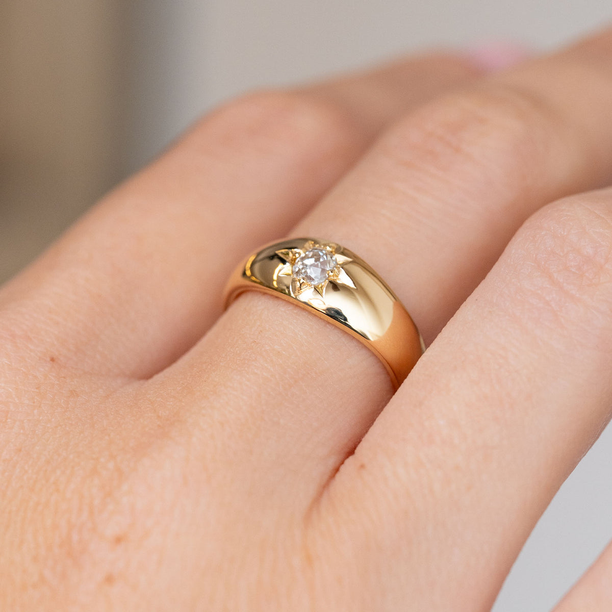 Close-up on-hand view of the antique gypsy ring, highlighting its diamond centre and hand-engraved star motif.