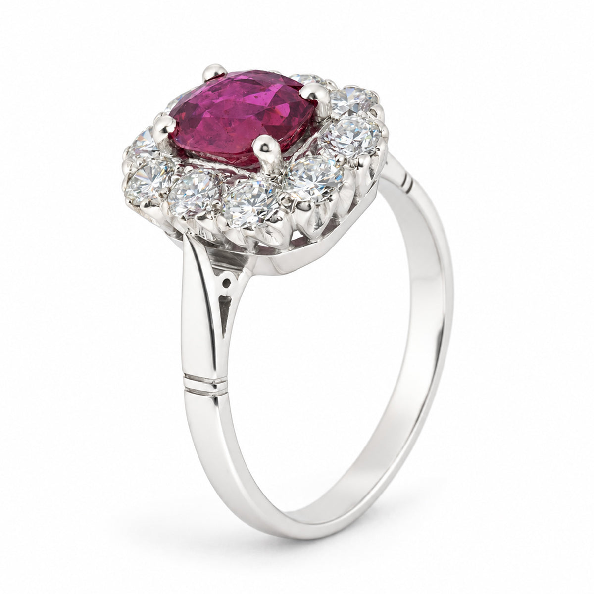 Three-quarter studio view of the ruby and diamond halo ring, showcasing its elevated cluster setting and elegant white gold band.