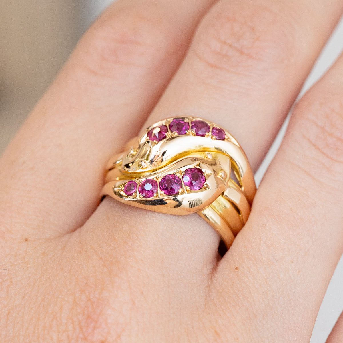 Detailed hand shot of the Victorian snake ring, showing four natural rubies set along each entwined serpent.
