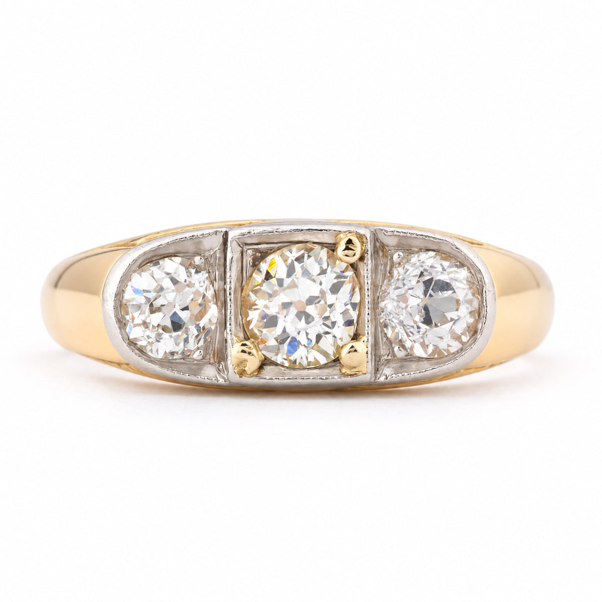 Antique Edwardian diamond three-stone engagement ring in yellow gold and platinum, featuring three round old-cut diamonds in a platinum setting with a broad yellow gold band.