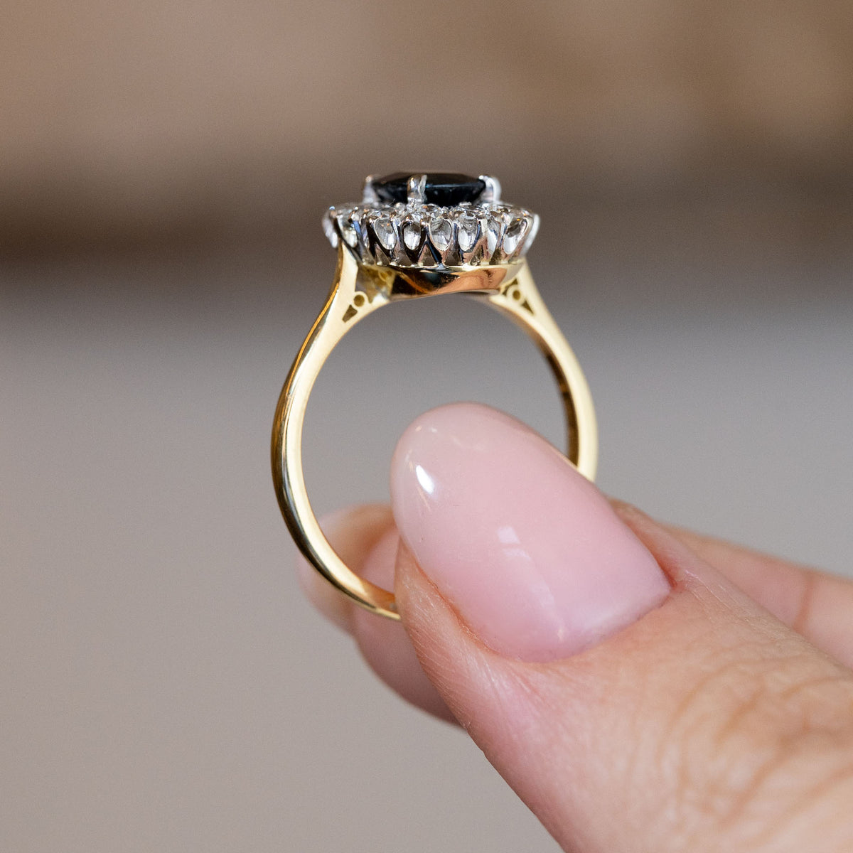 Side profile of the vintage sapphire and diamond ring, revealing the raised platinum gallery and polished yellow gold band.