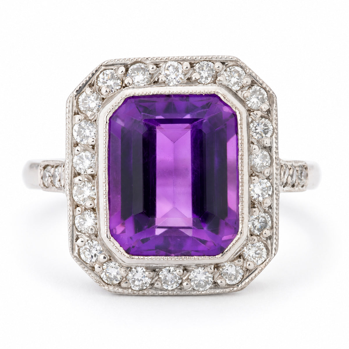 Antique Art Deco amethyst and diamond cluster ring in white gold, featuring a rectangular emerald-cut purple amethyst surrounded by a geometric halo of round diamonds with milgrain detailing.