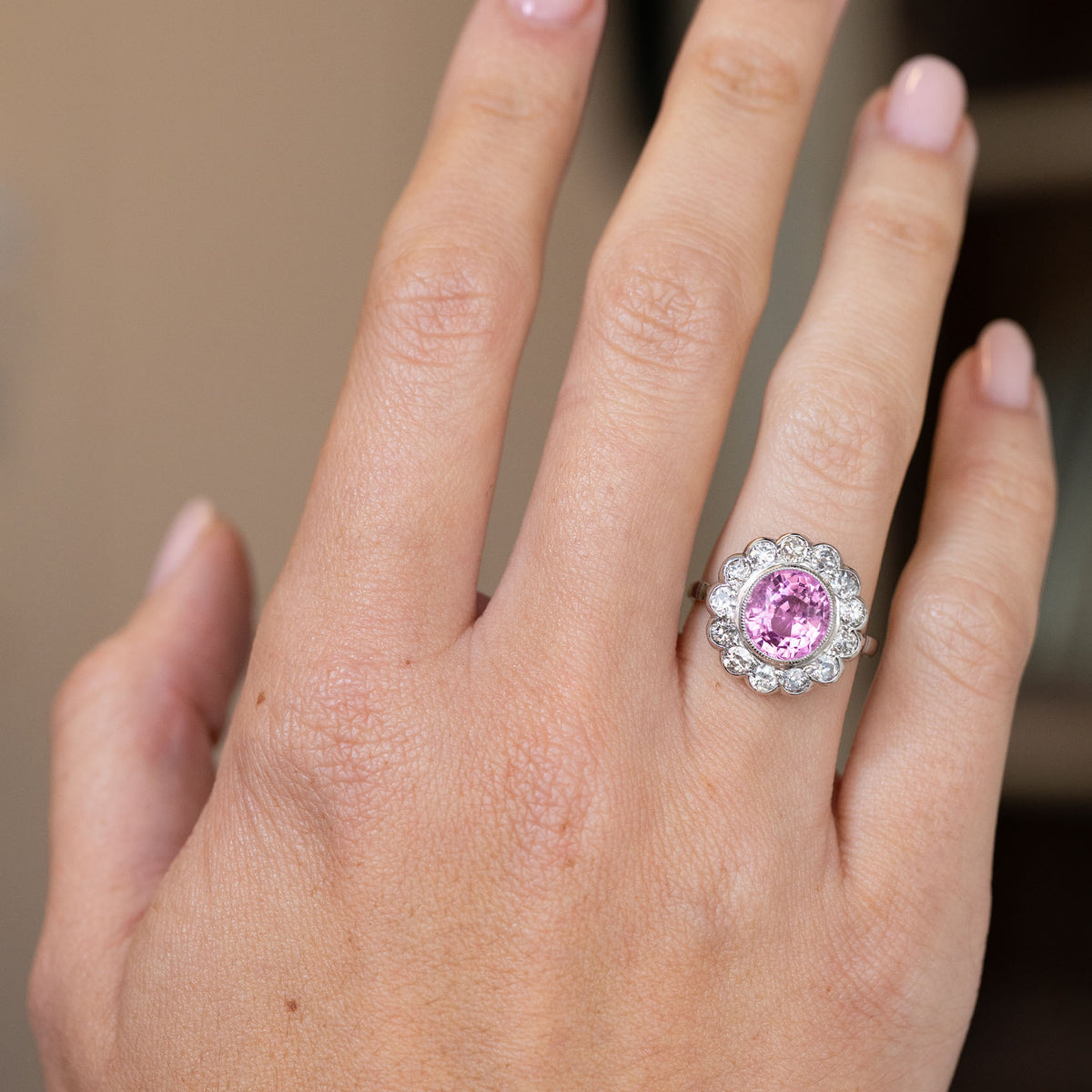 1960s pink sapphire and diamond engagement ring worn on the hand, displaying its bold vintage proportions.