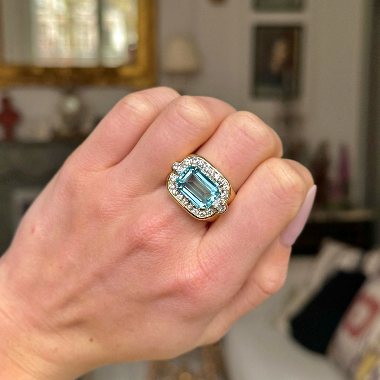 Aquamarine and diamond cocktail ring worn on closed hand.