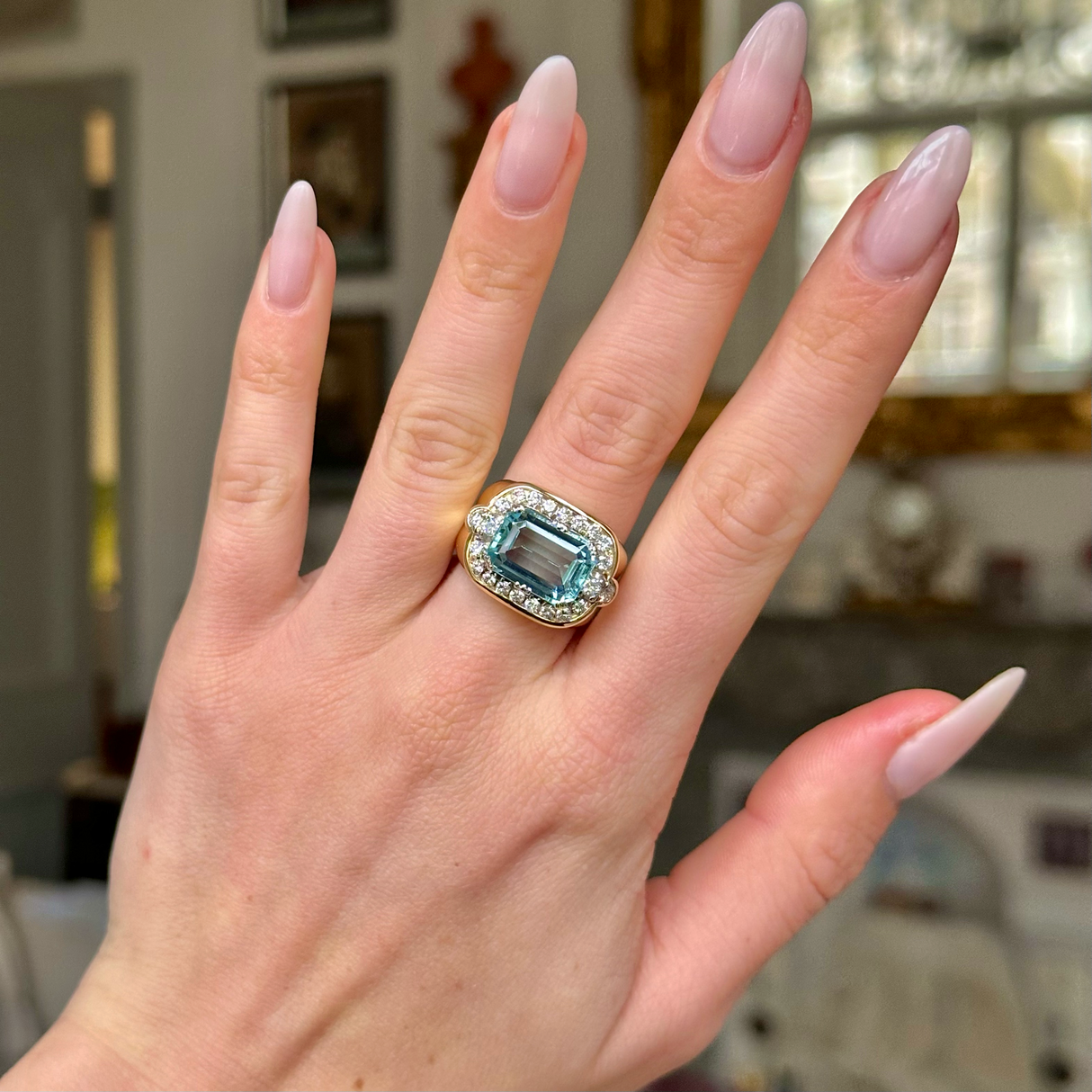 Aquamarine and diamond cocktail ring worn on hand.