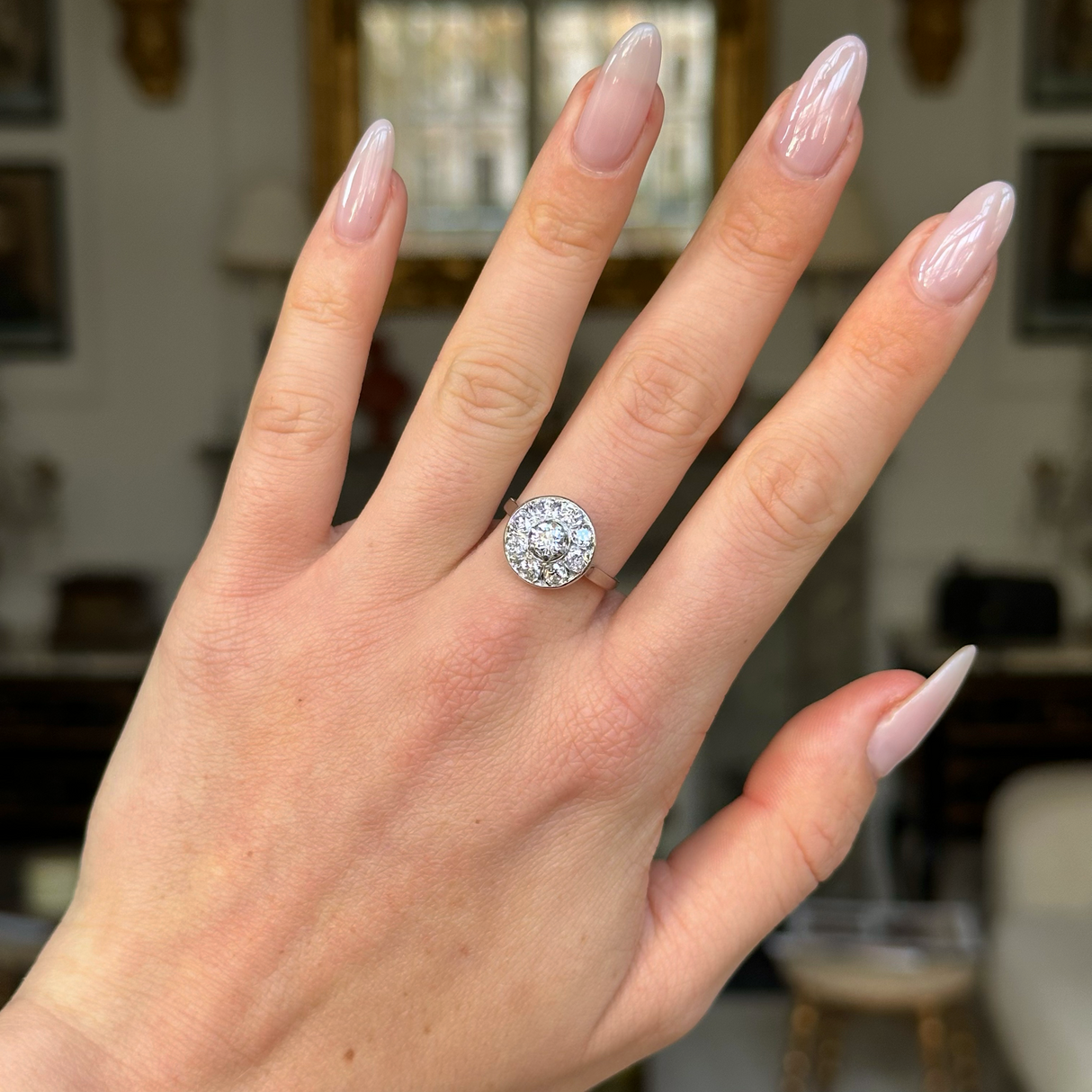 Art deco diamond cluster ring worn on hand.