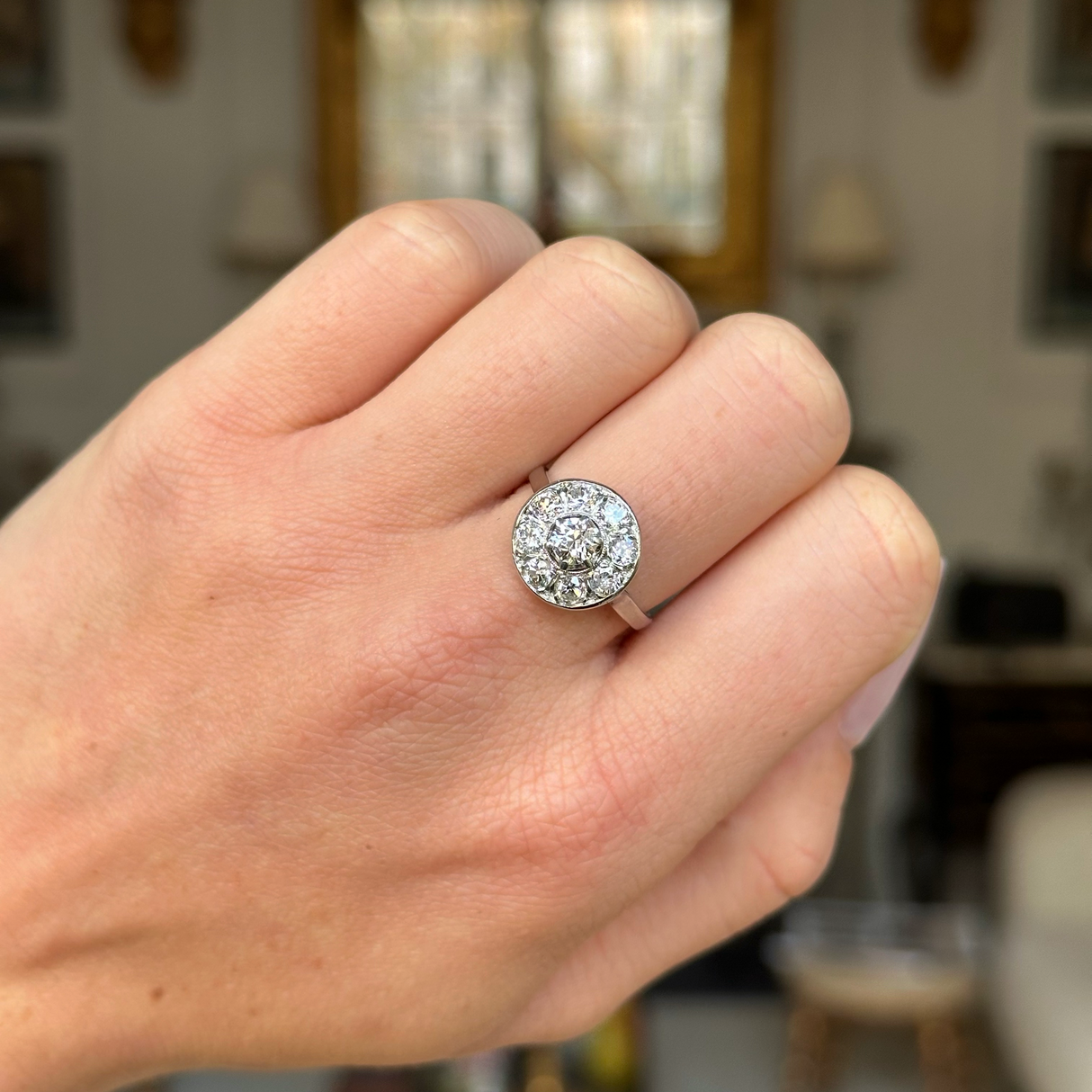 Art deco diamond cluster ring worn on closed hand.