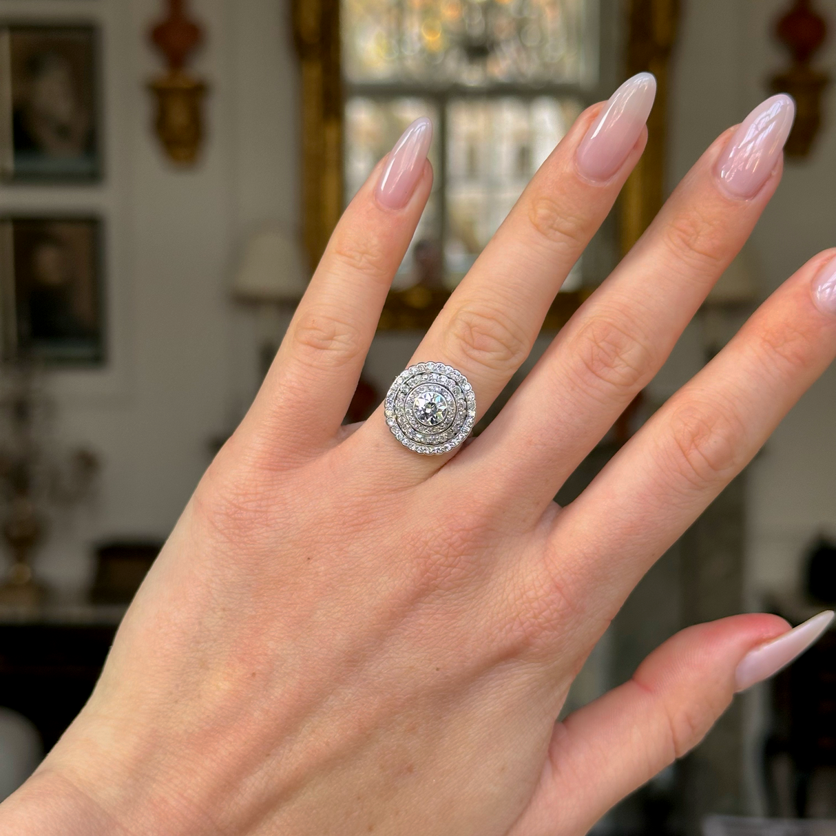 Art Deco diamond target cluster ring worn on hand.