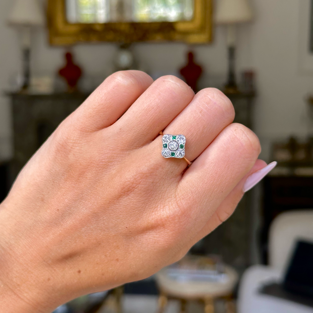Art Deco emerald and diamond kite shaped ring, worn on closed hand,front view.