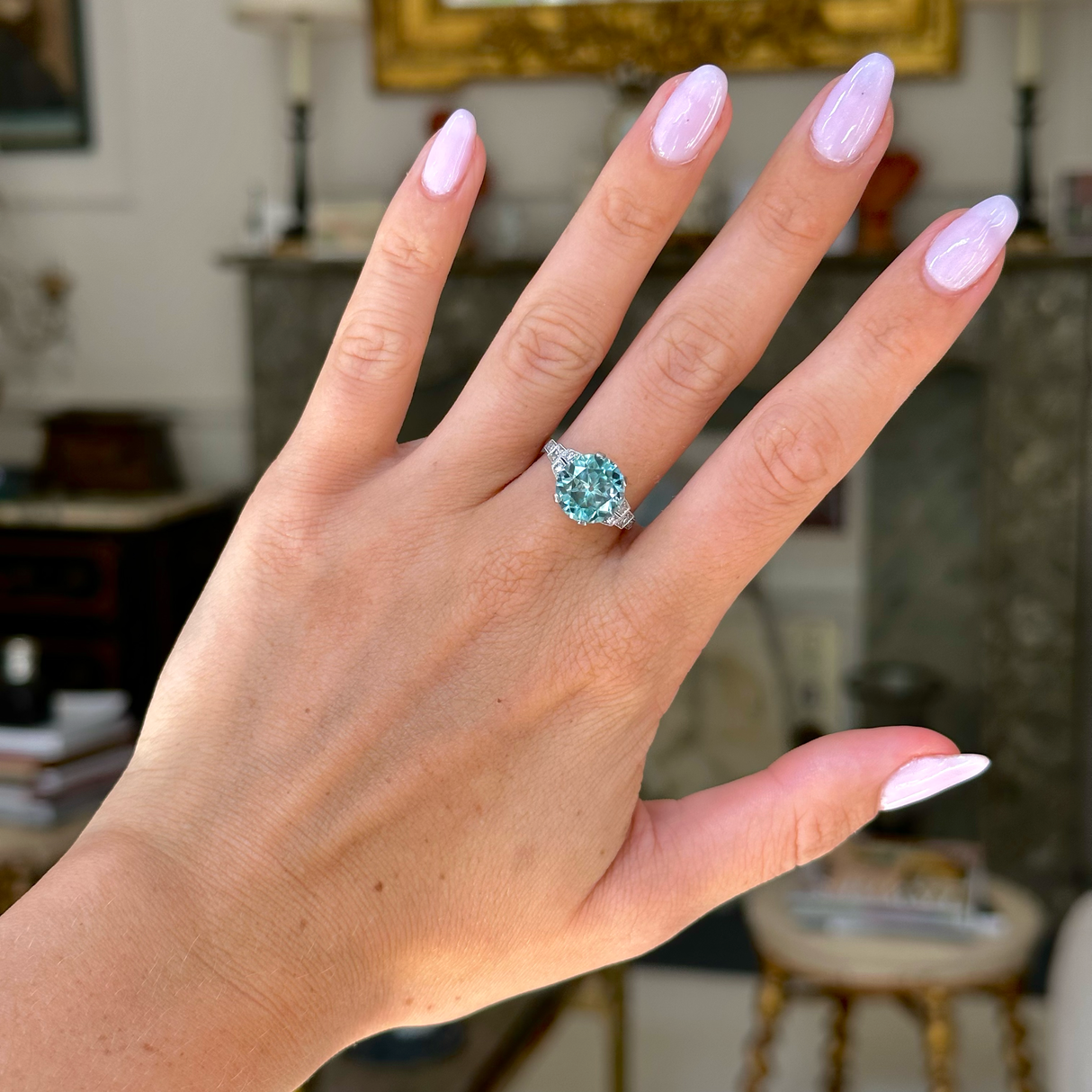 Art deco blue zircon and diamond ring, worn on hand, front view.