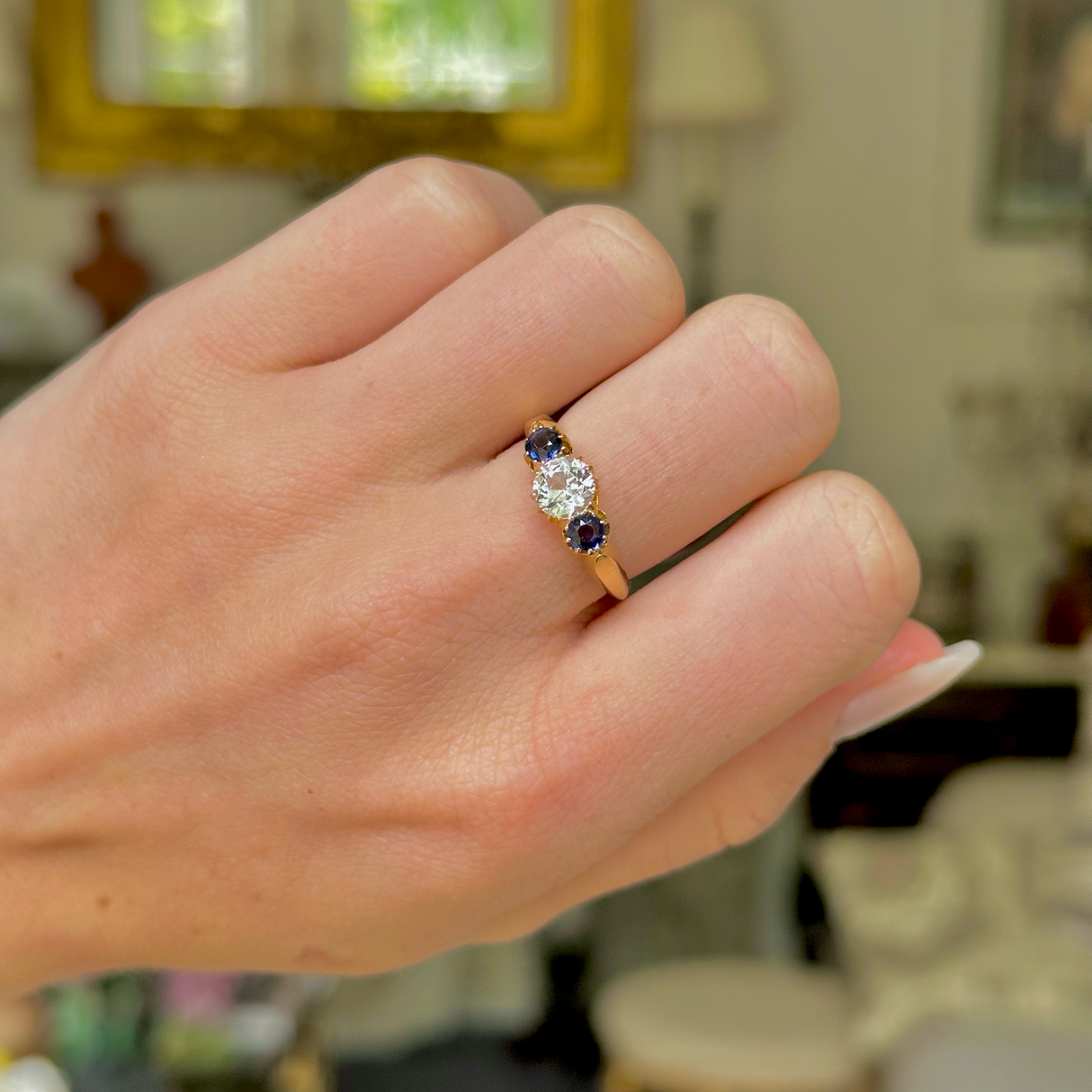 Antique, central white sapphire and blue sapphire three stone ring, 18ct yellow gold