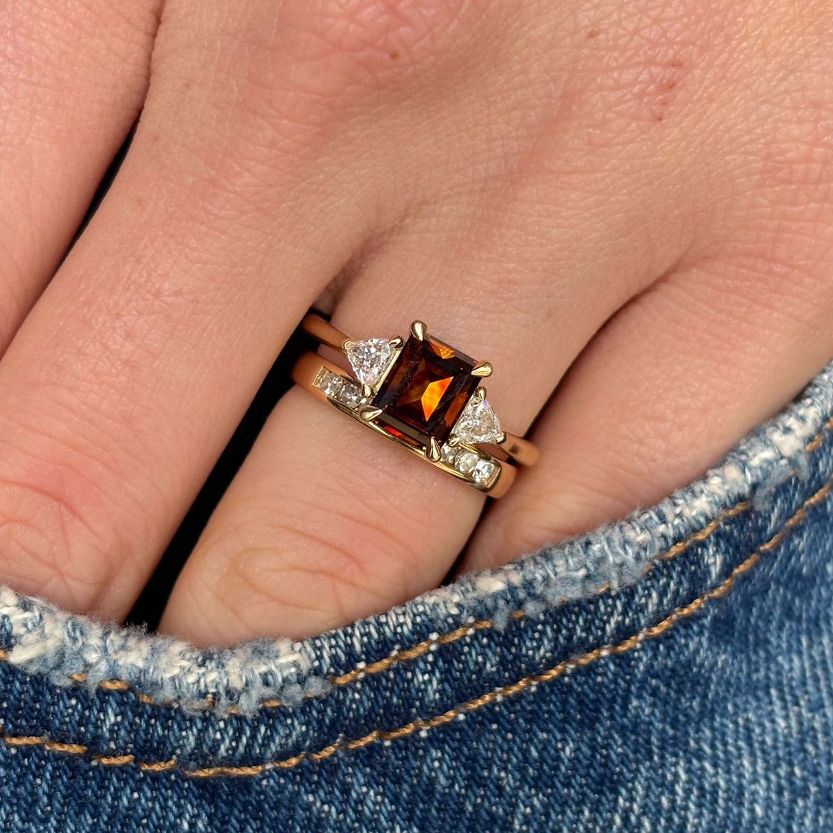 yellow gold brown diamond three-stone engagement ring on hand stacked with wedding band to show proportions