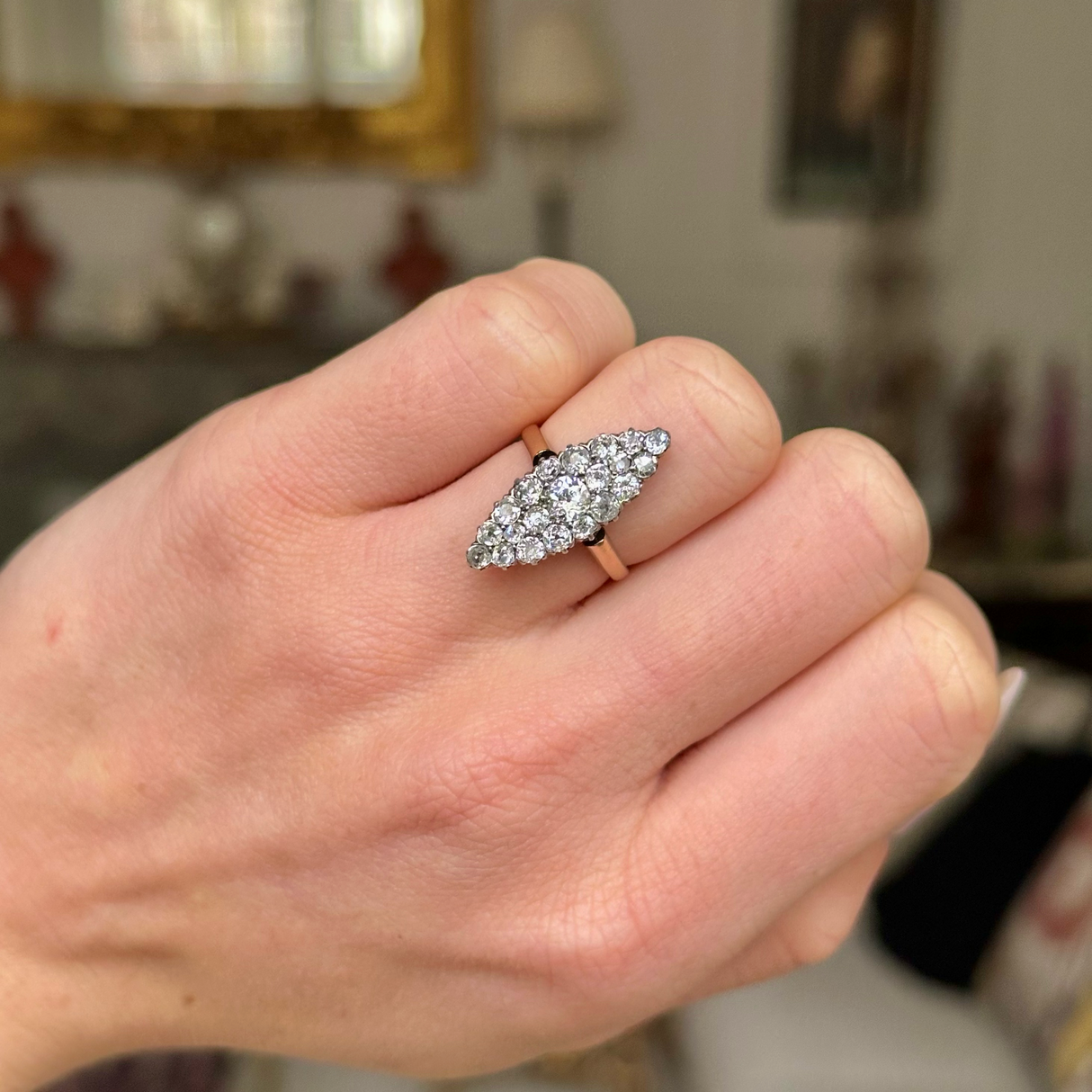 Antique diamond navette ring worn on closed hand.
