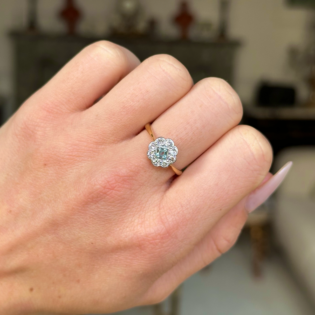 Edwardian aquamarine and diamond ring worn on closed hand.