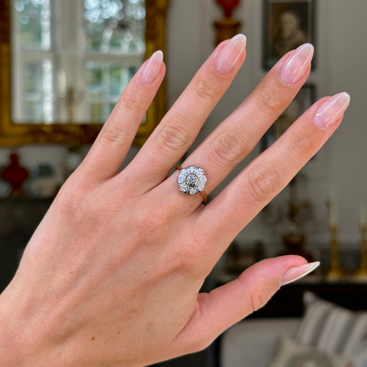 antique diamond daisy cluster engagement ring, worn on hand, front view.