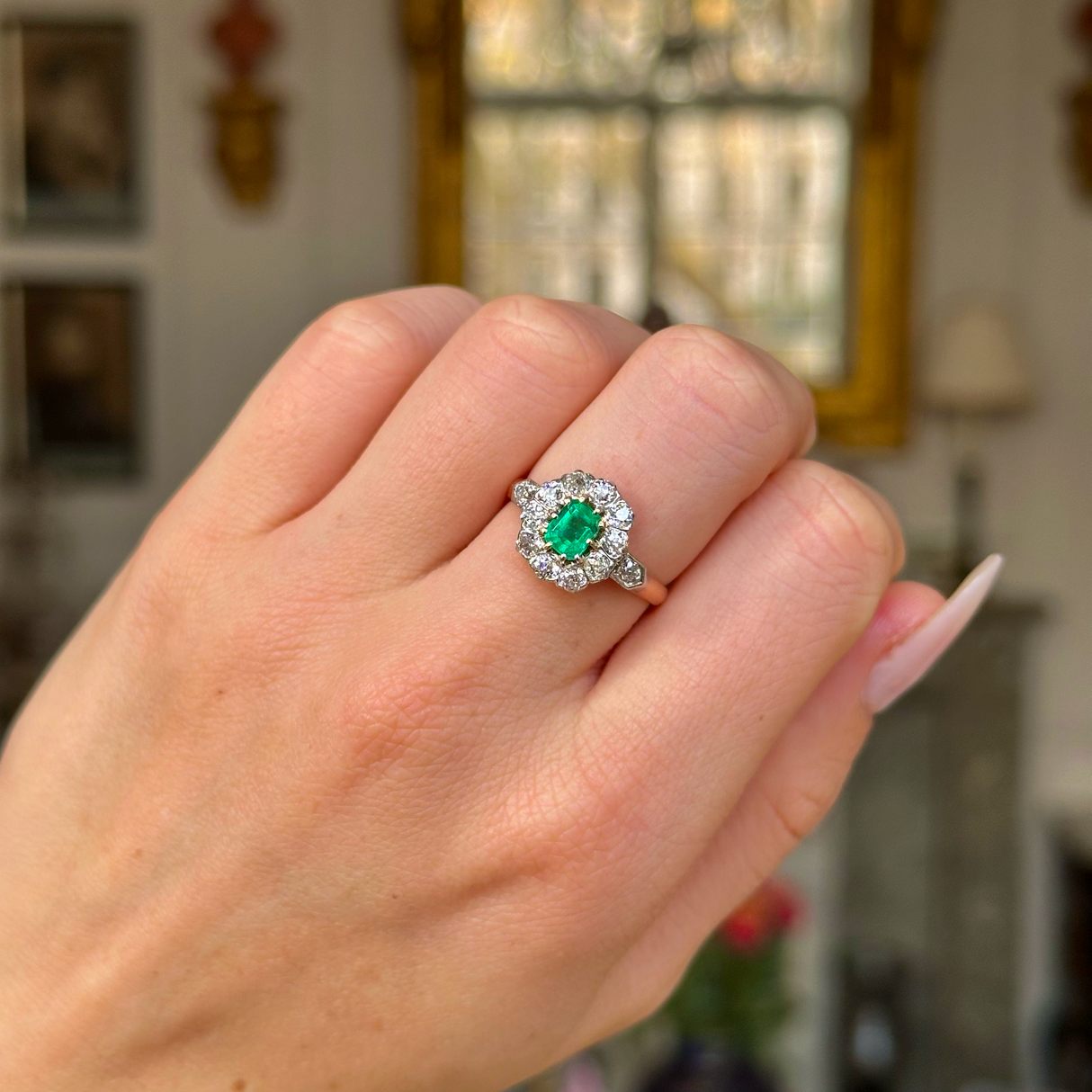 Edwardian emerald and diamond ring worn on closed hand.