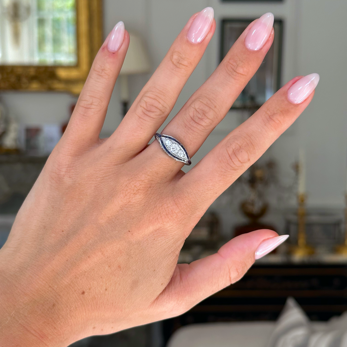 Antique Edwardian sapphire and diamond ring worn on hand.