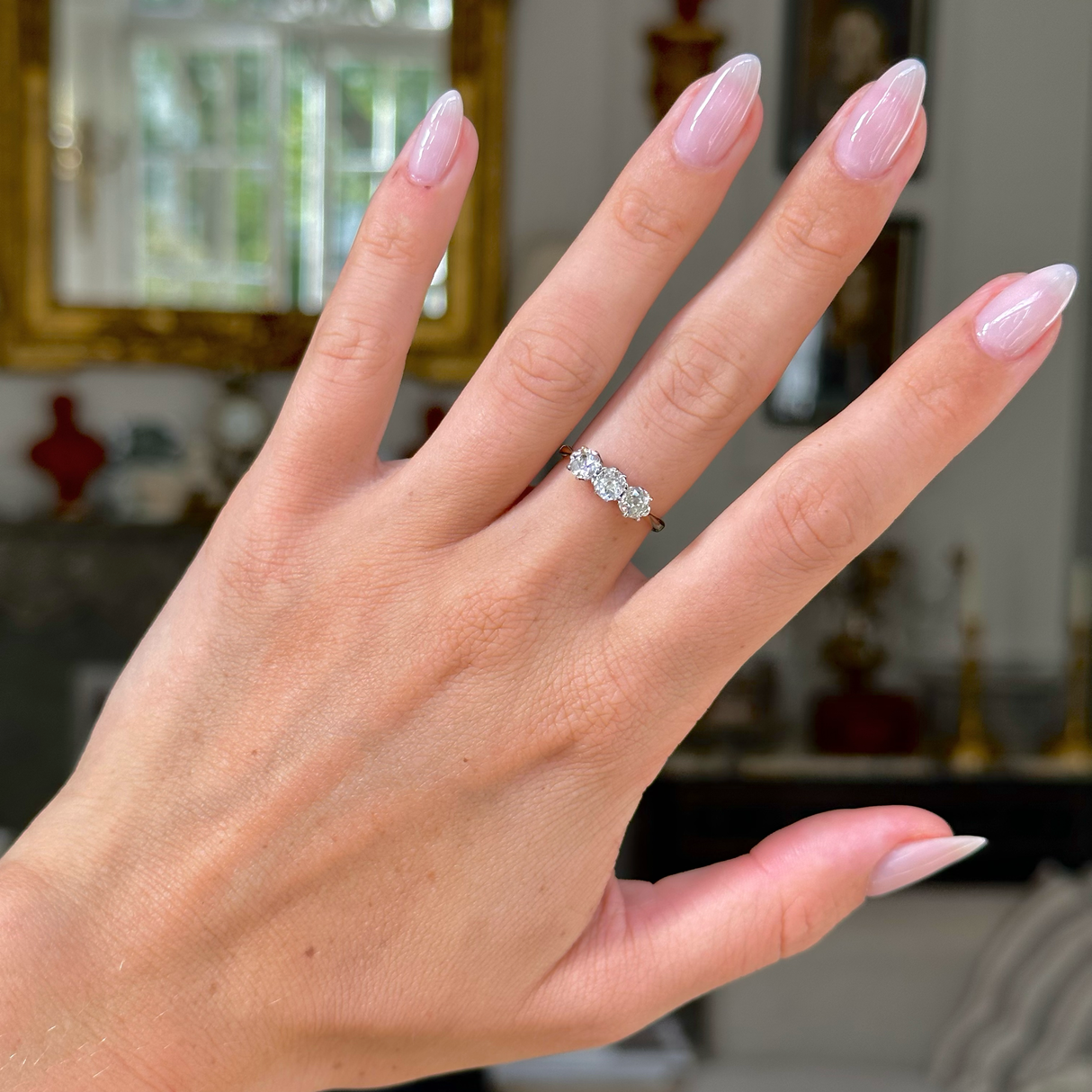 antique three stone diamond engagement ring, 18ct yellow gold band, worn on hand, front view.