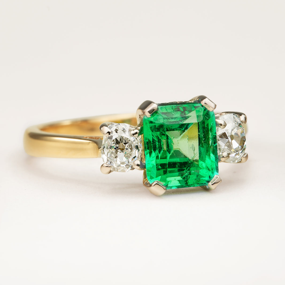 Vintage, emerald and diamond three-stone engagement ring
