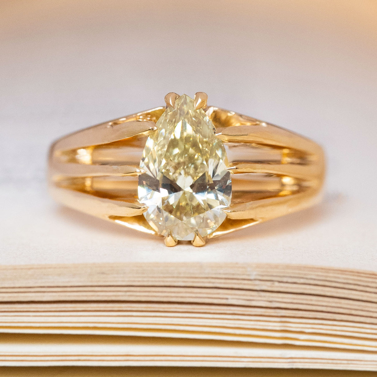 An antique, Edwardian yellow pear-cut diamond solitaire gypsy ring in yellow gold.