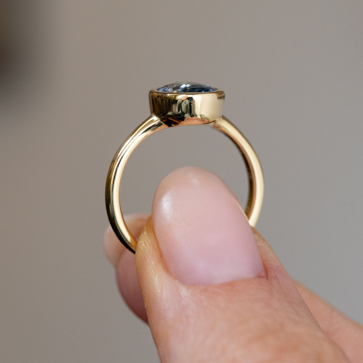 Profile view of the antique-inspired engagement ring, displaying the elevated rub-over setting and polished yellow gold shank.