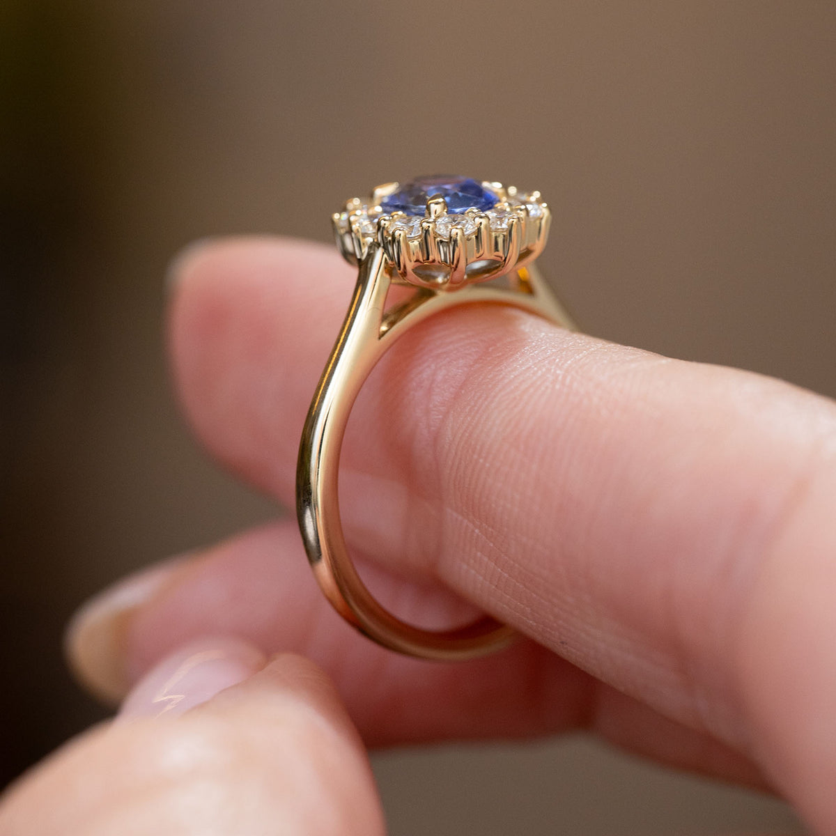 Profile detail of the antique-inspired cluster ring, showing the elevated sapphire setting, open gallery and polished yellow gold band.
