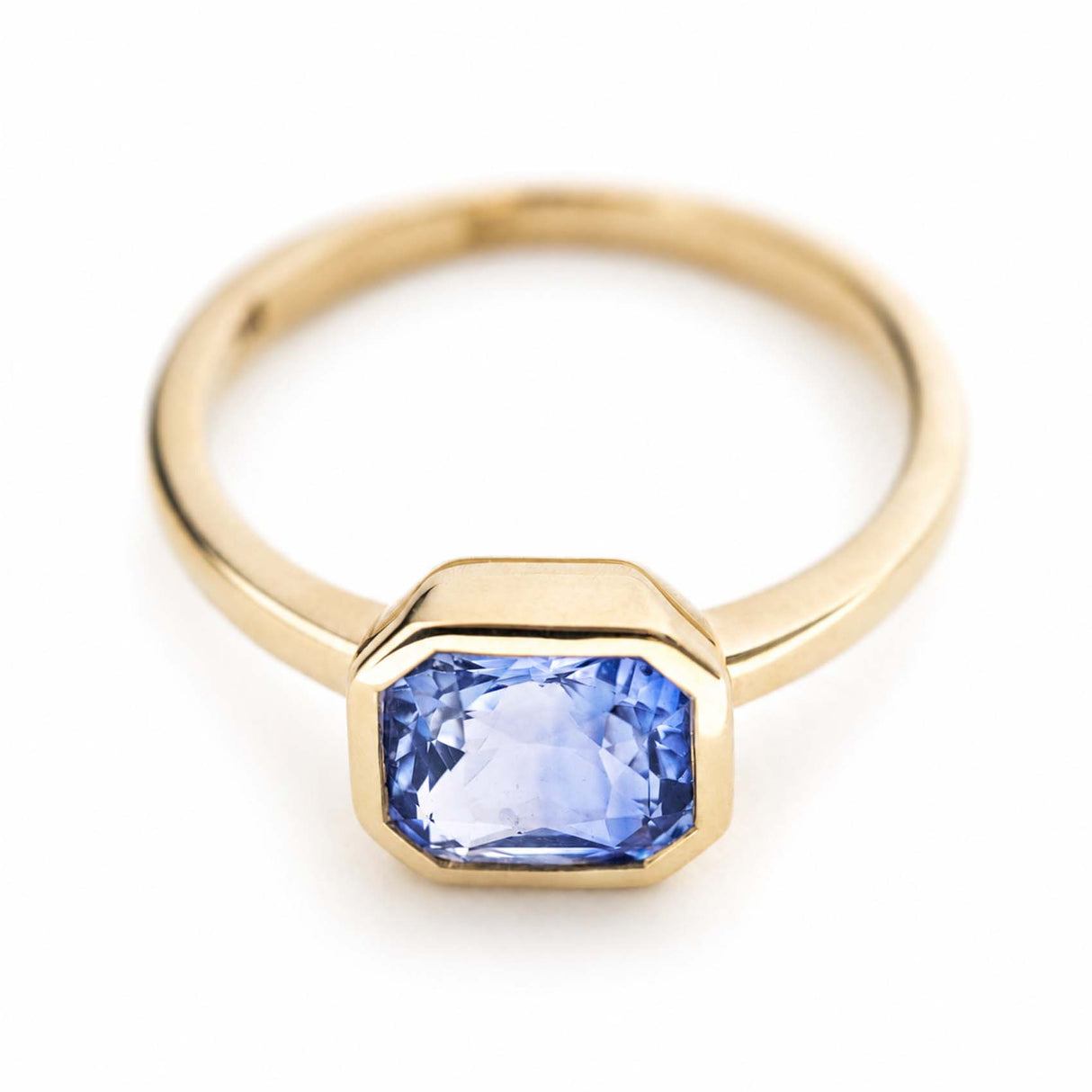 A vintage-inspired, blue sapphire solitaire yellow gold engagement ring.