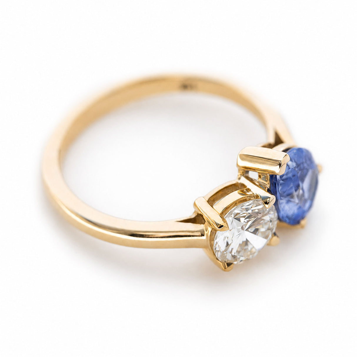 Angled view of a pear-cut blue sapphire and round diamond Toi et Moi ring