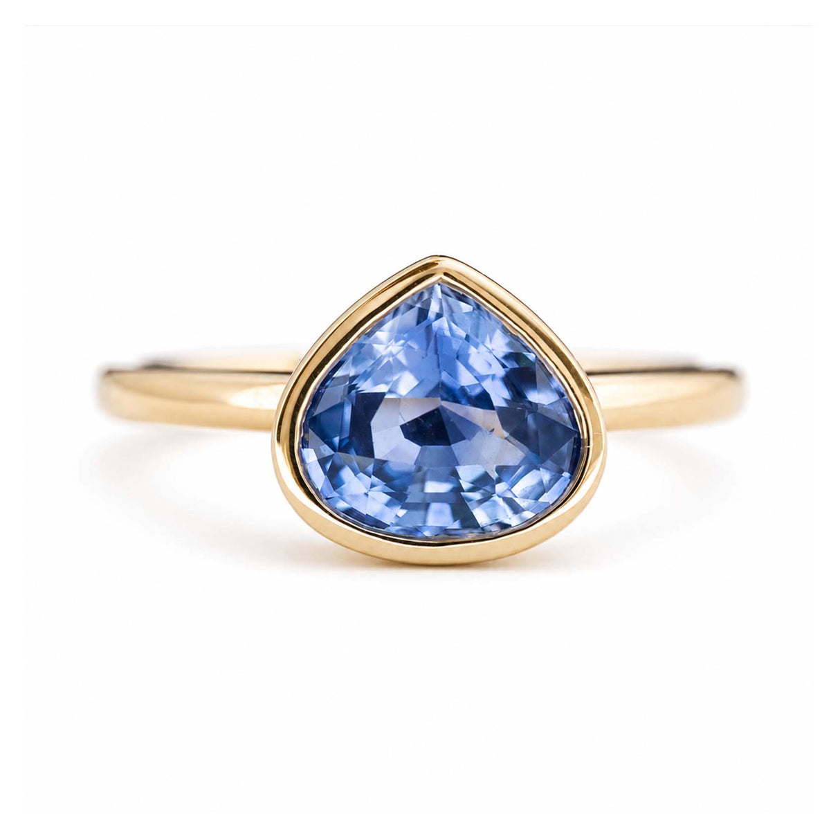 A yellow gold antique-inspired solitaire engagement ring with a blue sapphire at the centre.