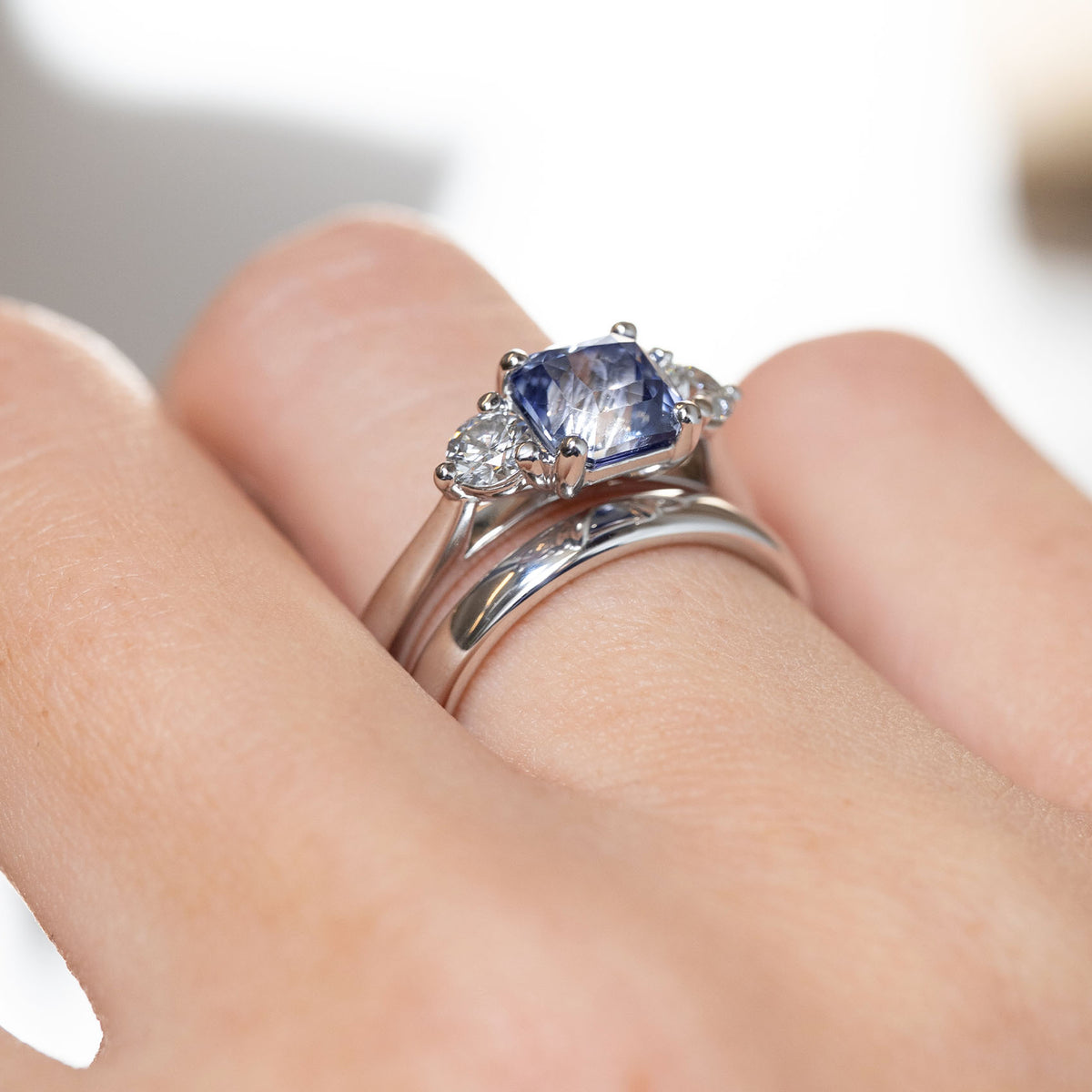 Side-angle view of the blue sapphire engagement ring paired with a wedding band, showcasing its wed-fit design for a flush-fitting wedding ring.