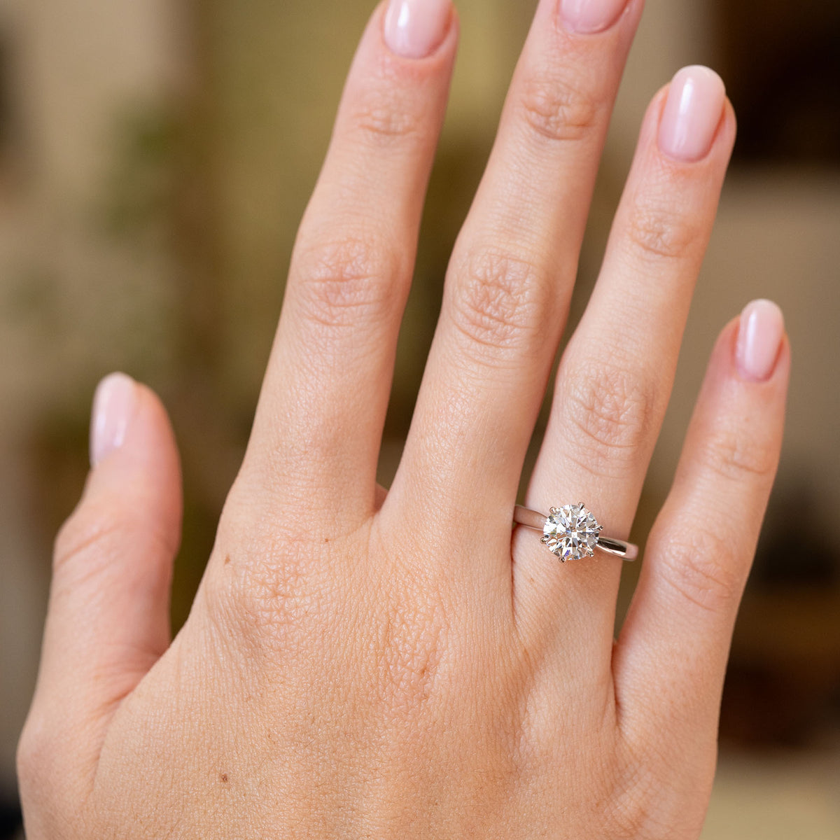 Full-hand view of a vintage round brilliant-cut lab-grown diamond solitaire ring in timeless white gold.