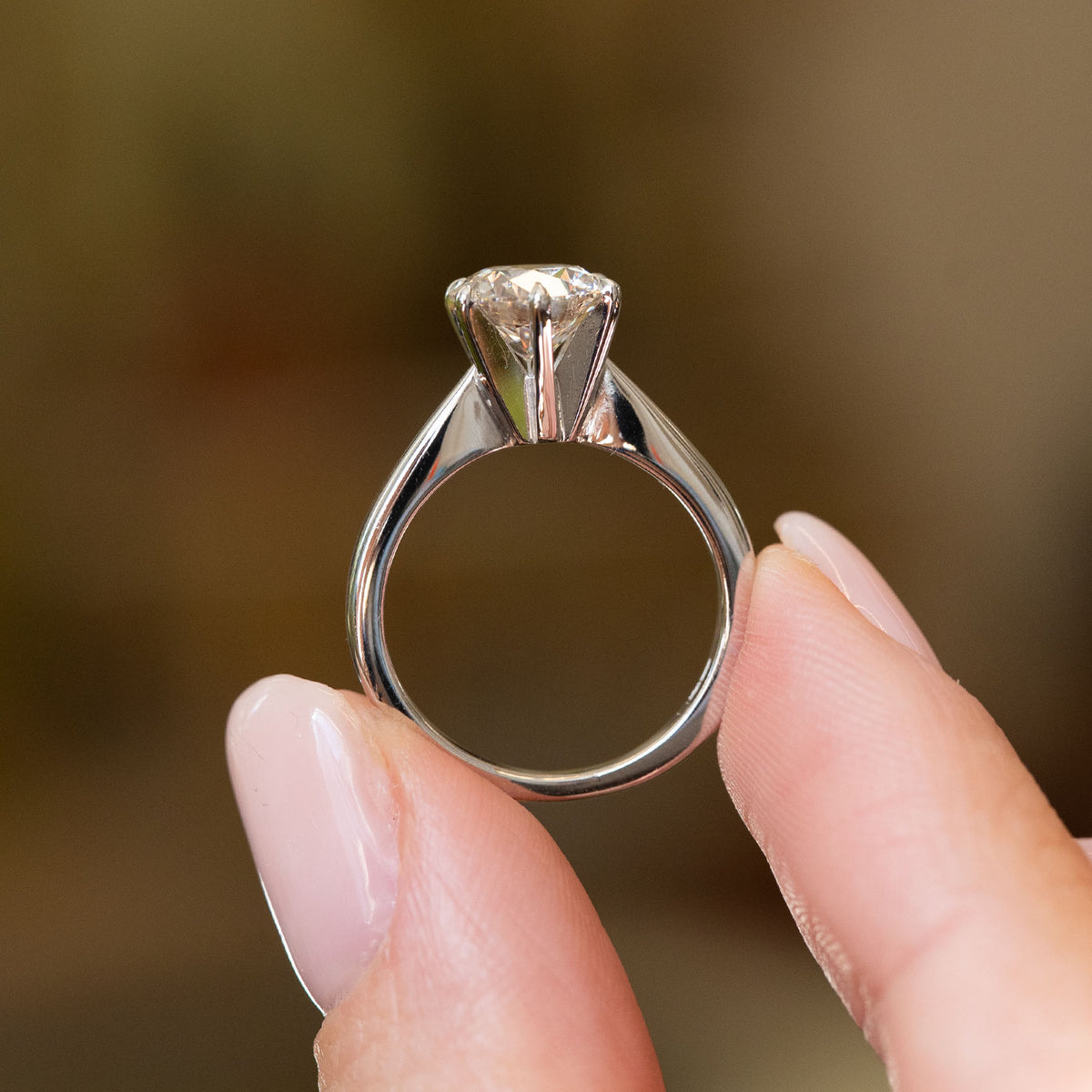 Profile view of a vintage lab diamond engagement ring, displaying the elevated claw setting and substantial white gold band.