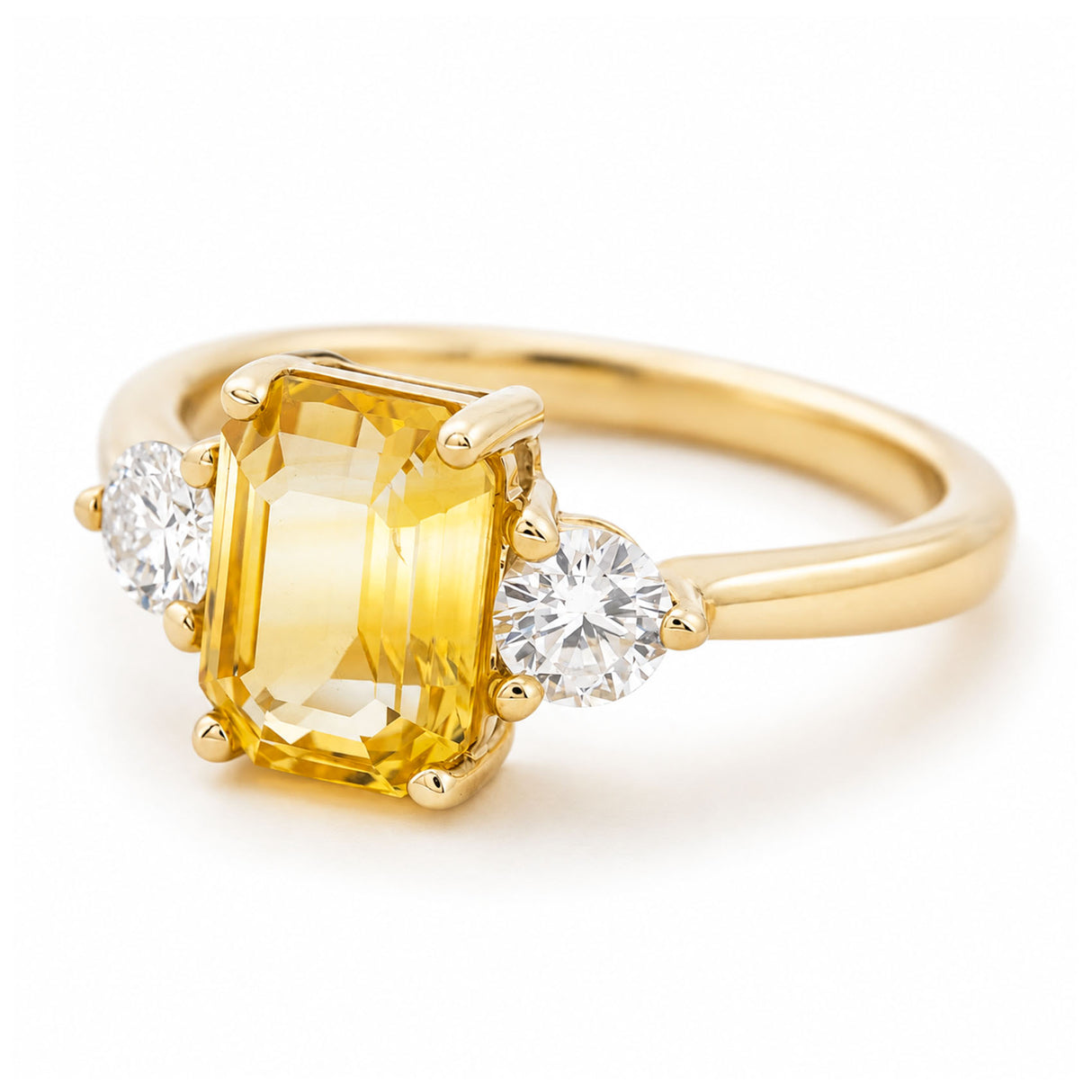 A vintage-inspired yellow gold engagement ring with a sunflower yellow sapphire at the centre flanked by two round diamonds.