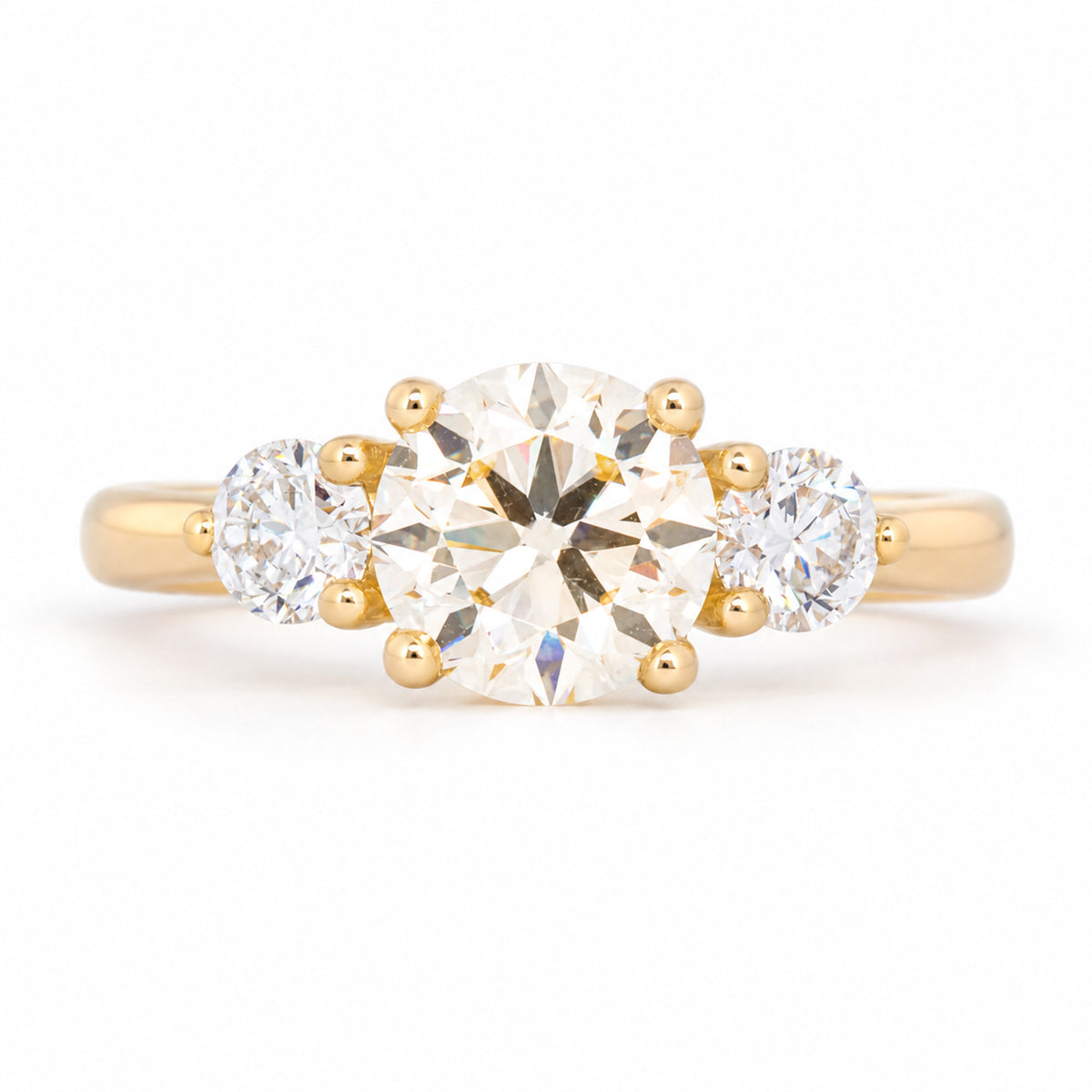 Antique-inspired pale yellow oval diamond three-stone engagement ring in yellow gold, front view.