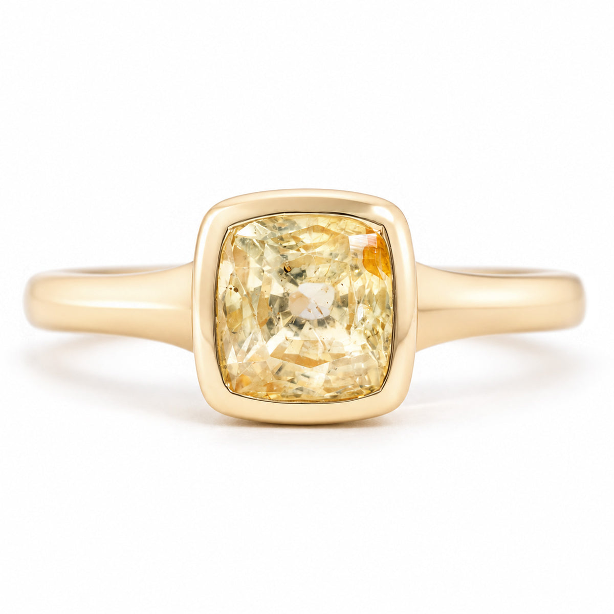 Front view of an antique-inspired yellow sapphire solitaire engagement ring, featuring a square cushion-cut gemstone in a polished yellow gold bezel setting.