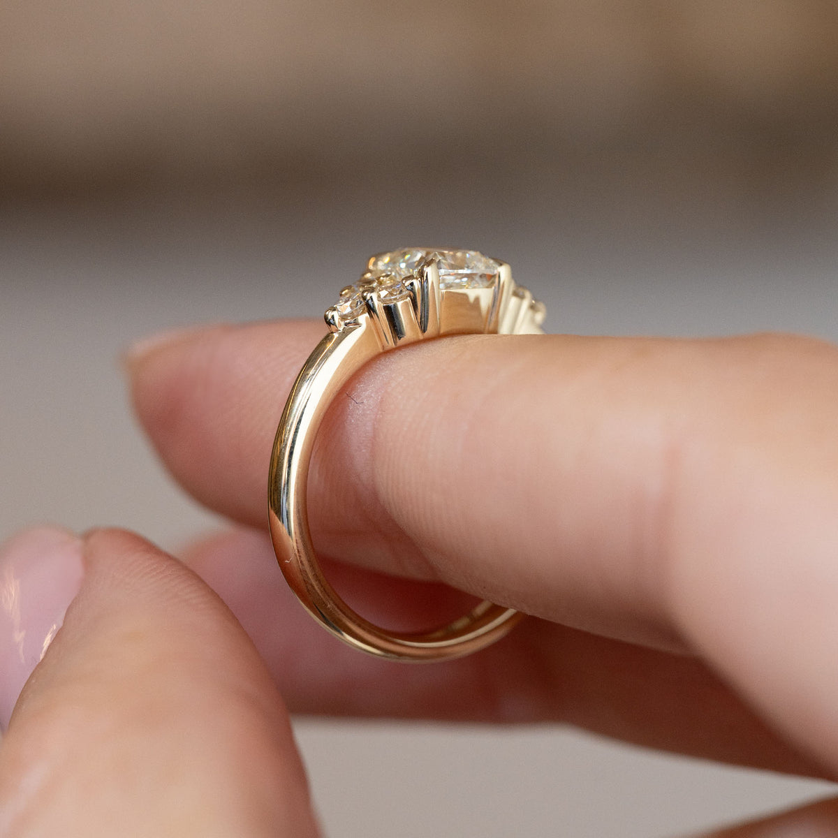 Side profile of the vintage-inspired trefoil engagement ring, revealing the raised diamond setting and polished yellow gold band.