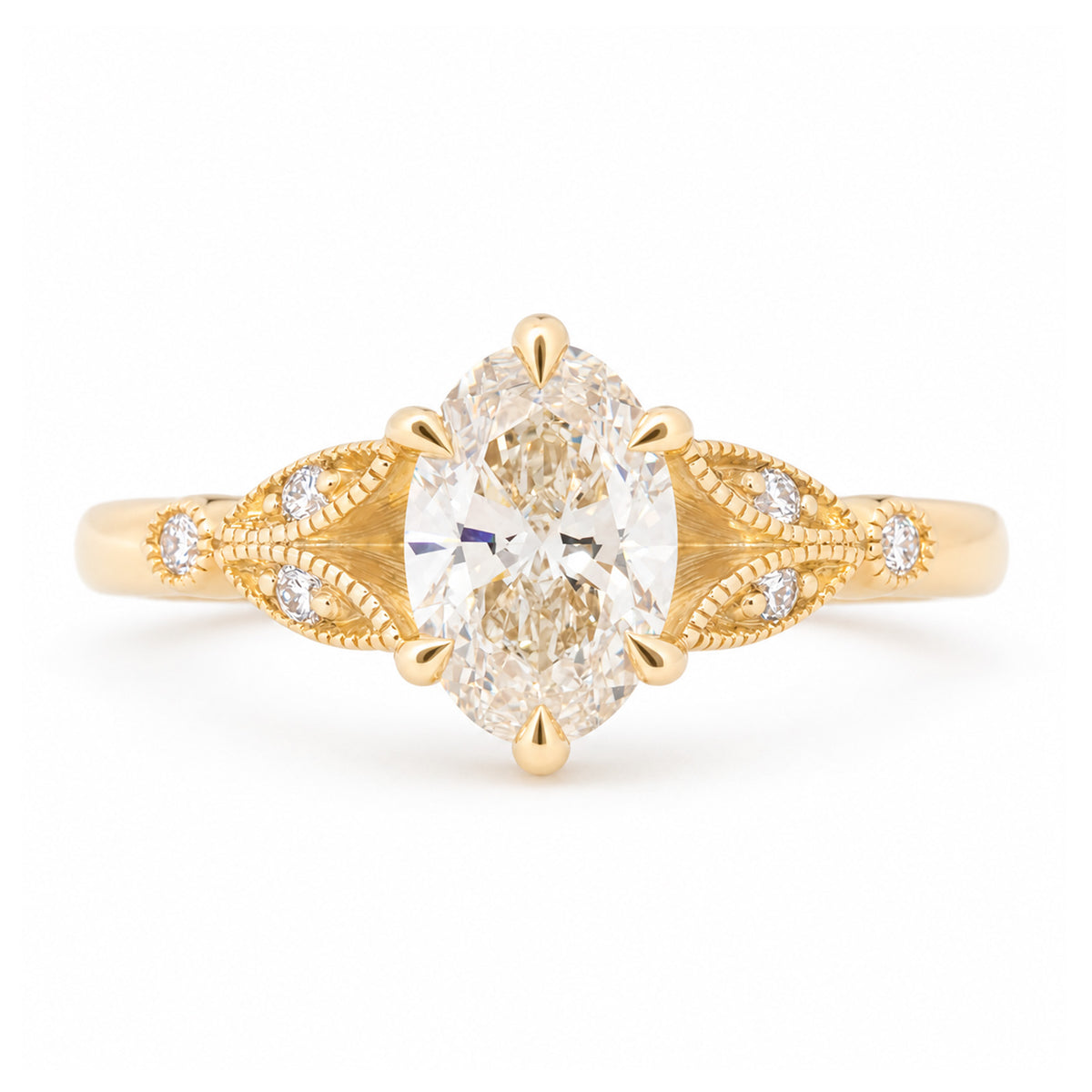 Vintage-inspired pale yellow diamond engagement ring with decorative laurel-leaf trefoil shoulders in yellow gold.