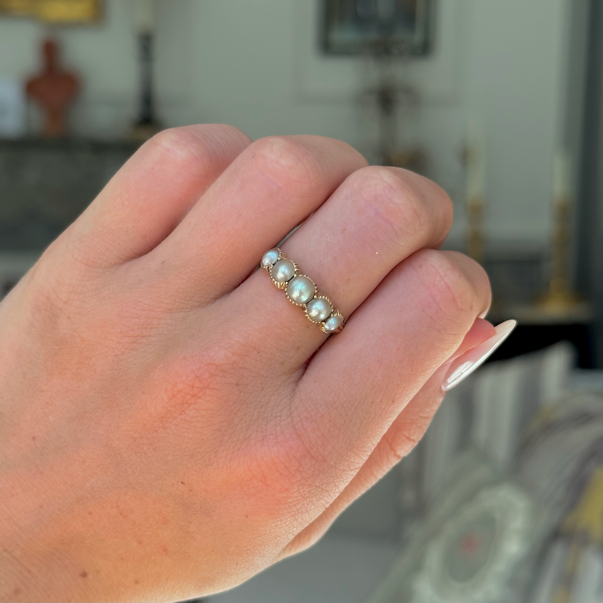 antique georgian pearl half hoop ring worn on closed hand, front view.