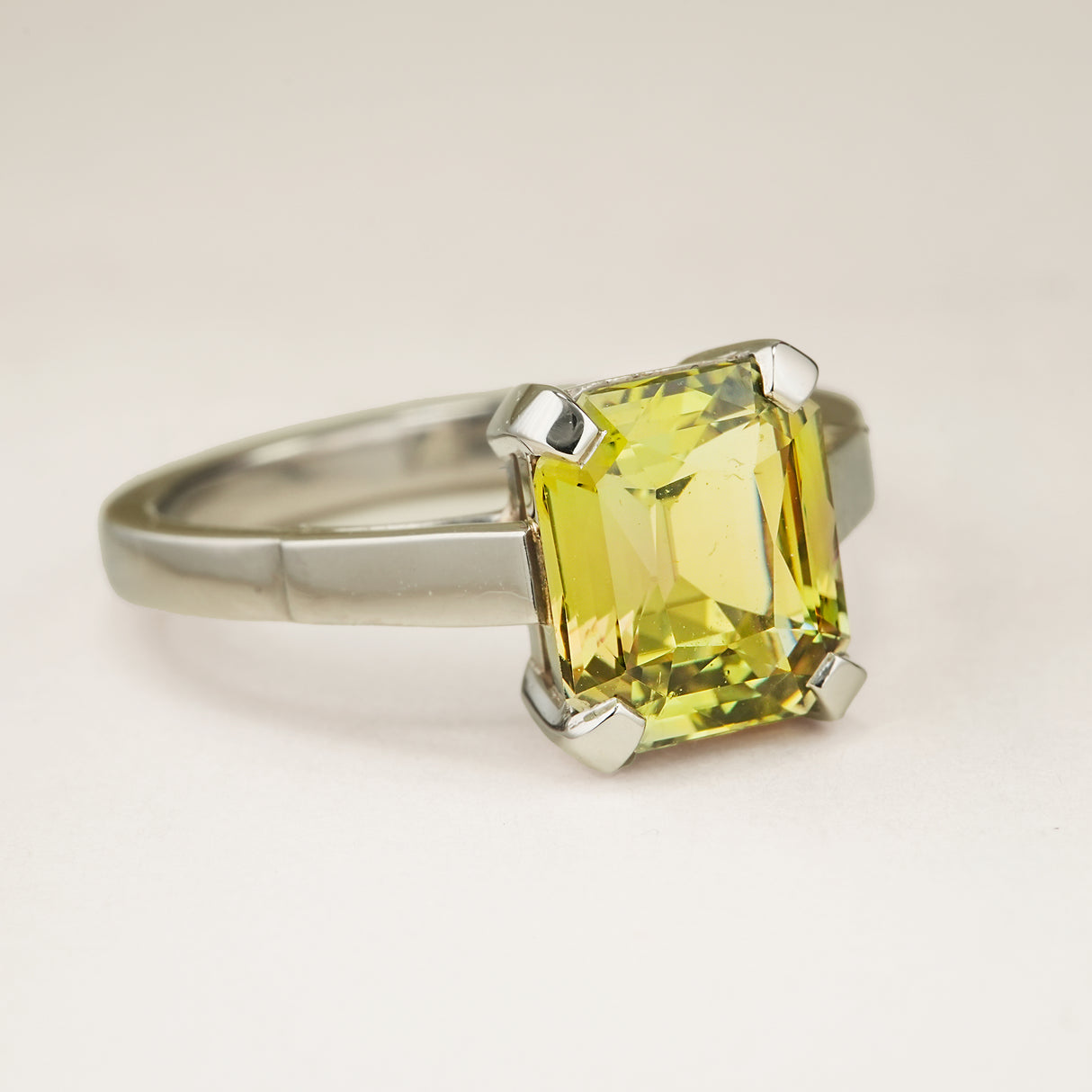 Green and brown colour-change sapphire solitaire engagement ring