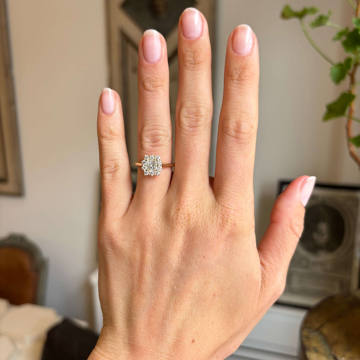 Antique-inspired, princess-cut diamond cluster engagement ring in yellow gold worn on a hand