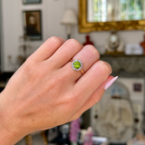 Edwardian peridot and diamond cluster ring,worn on closed hand.