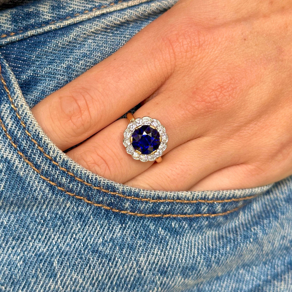 belle epoque sapphire and diamond cluster ring, worn on hand placed in pocket of jeans,front view.