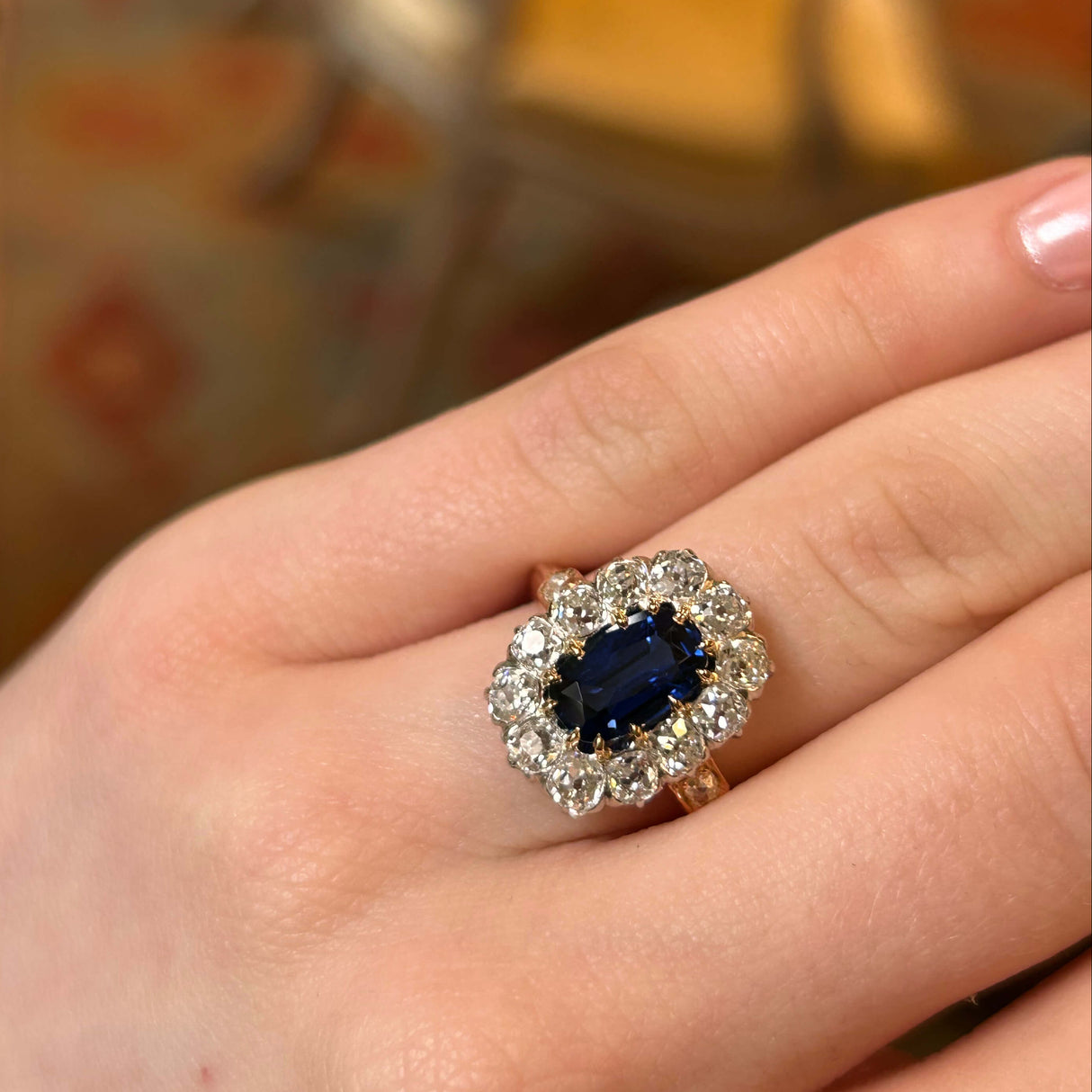 Ring sapphire and diamond cluster on a hand details