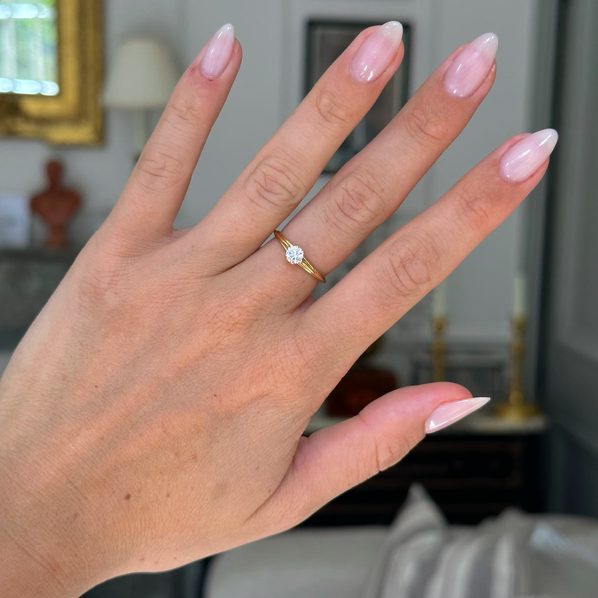 Vintage solitaire diamond engagement ring, worn on hand.