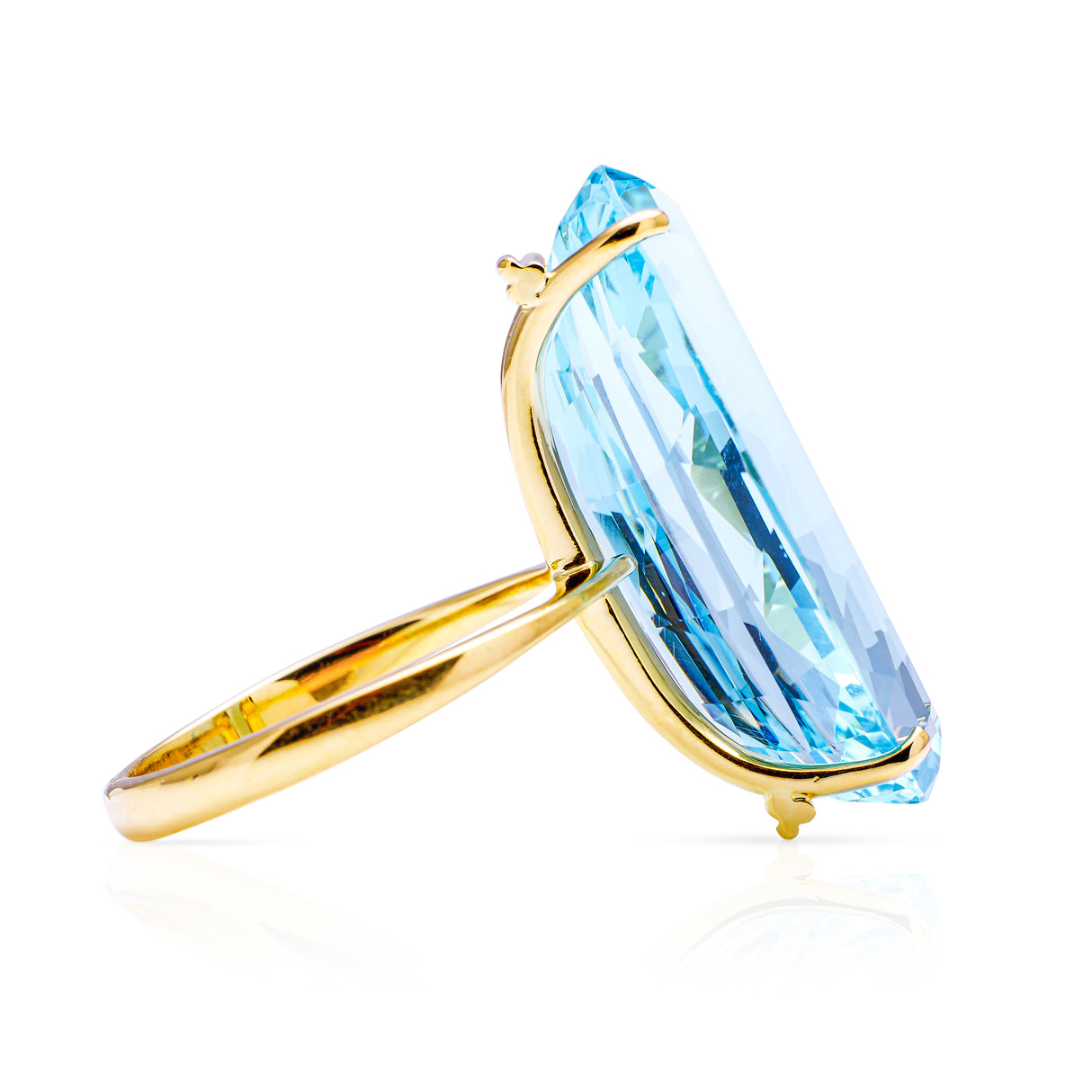 Large aquamarine and yellow gold cocktail ring on a white background, side of ring perspective.