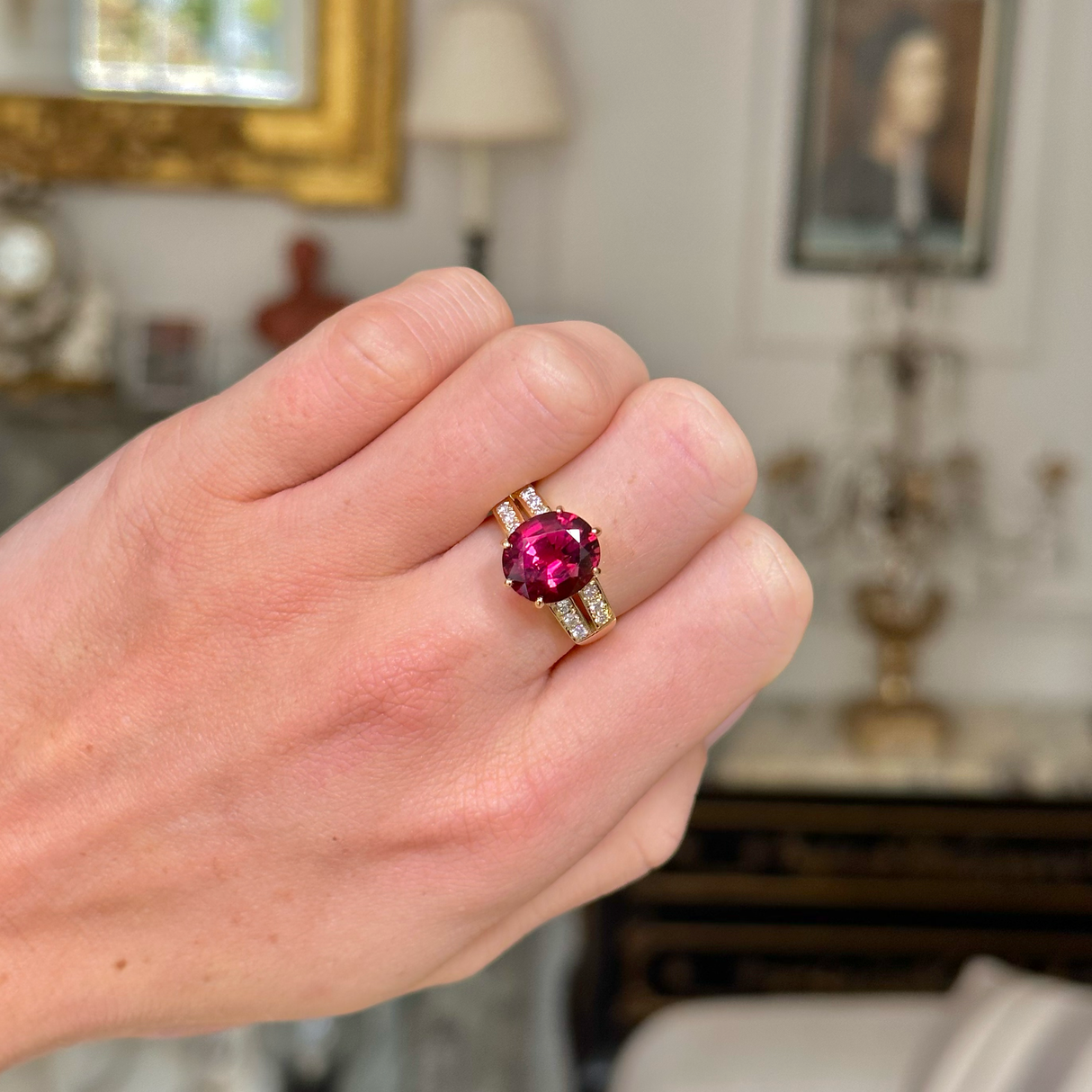 Red tourmaline and diamond cocktail ring, worn on closed hand, front view. 