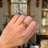 Three stone citrine ring worn on closed hand.