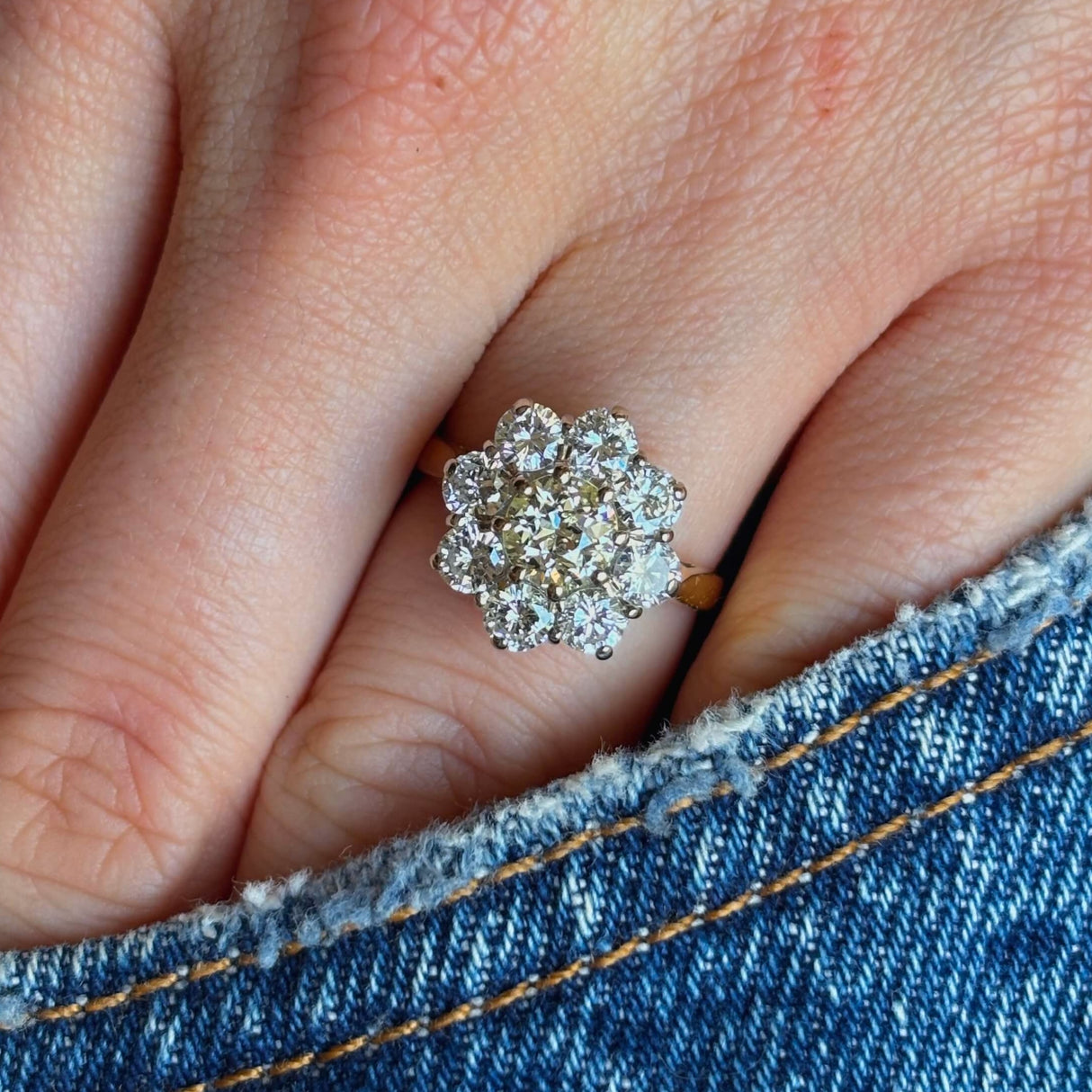 Vintage, 1980's diamond cluster ring worn with hand placed in pocket of jeans.