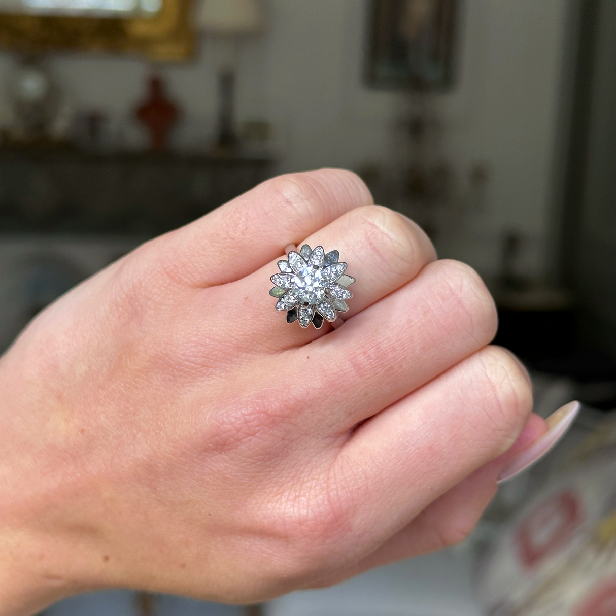 french diamond engagement ring resembling a flower worn on closed hand, front view. 