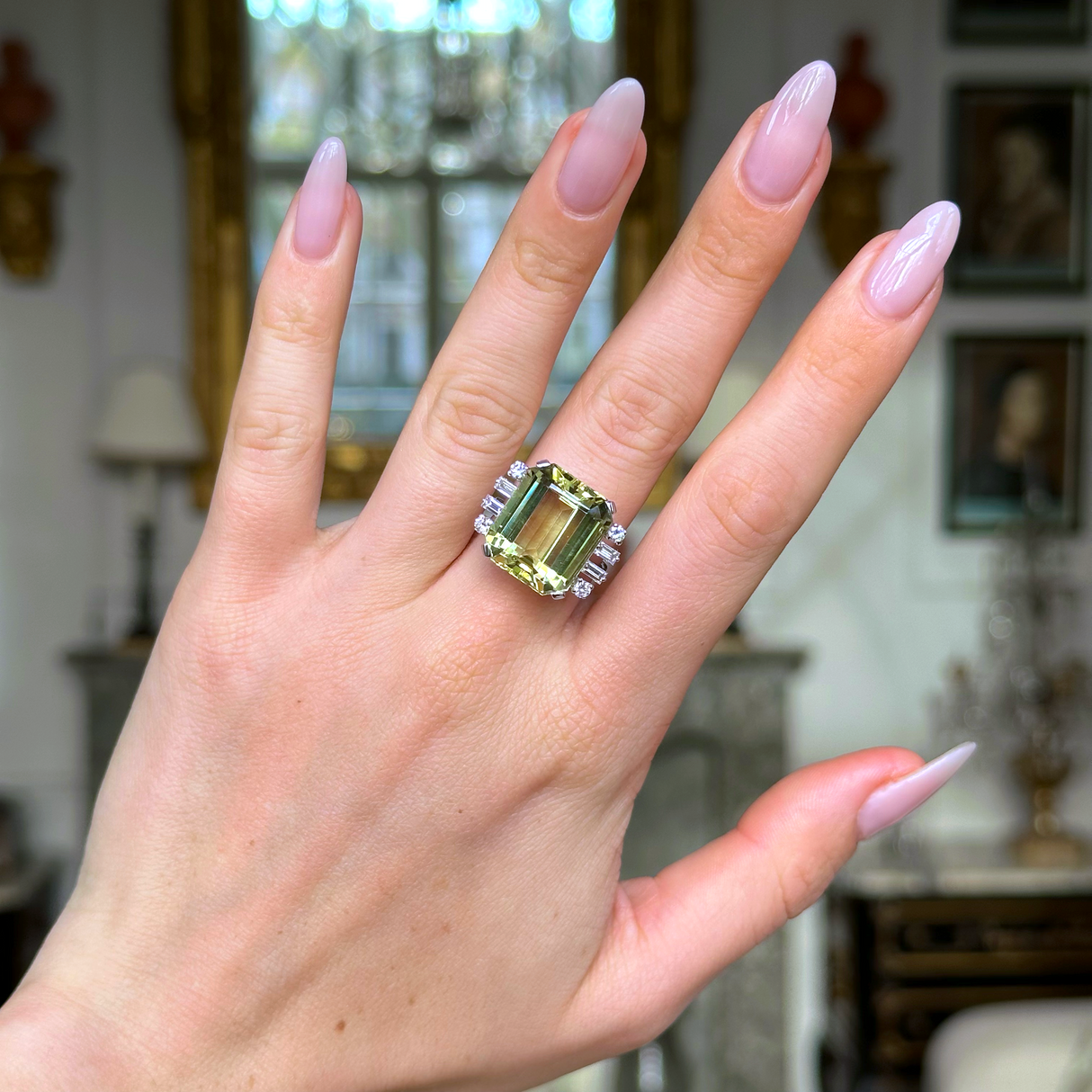 Vintage green heliodor and diamond ring worn on hand.